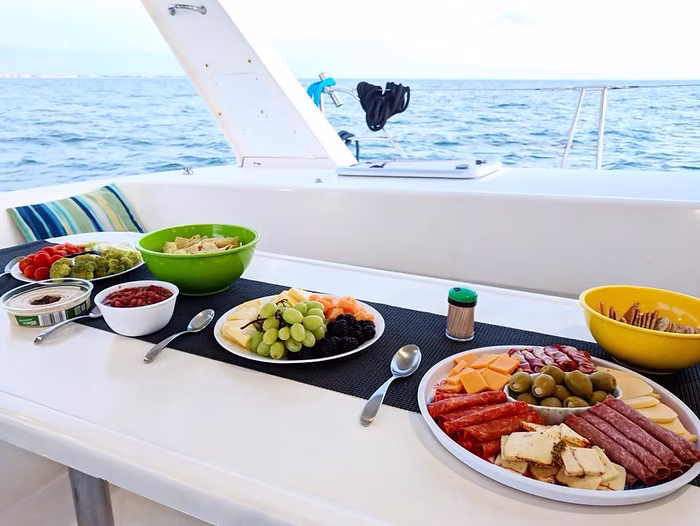 colorful food spread across cockpit table on a catamaran preparing for charter